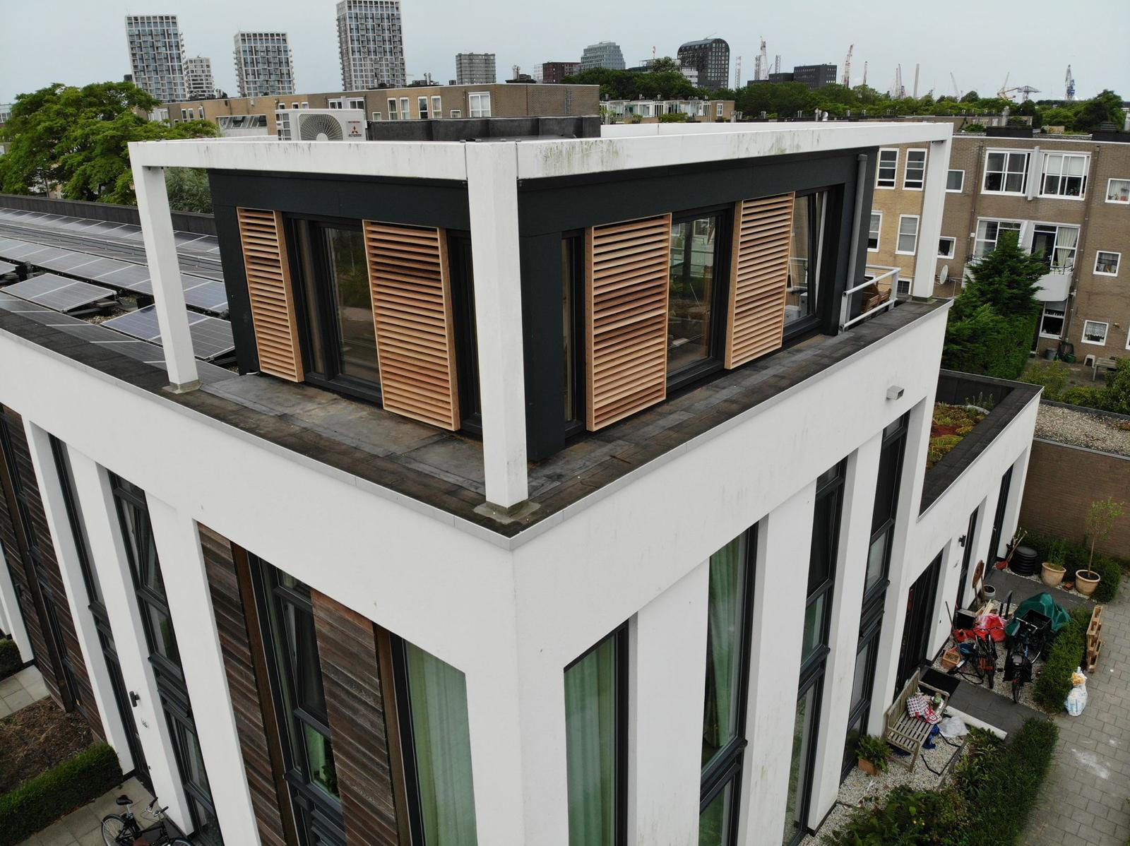 Dakopbouw met houten shutters op rijtjeswoning